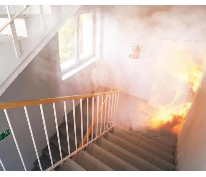 Fire and smoke pours into a stairwell