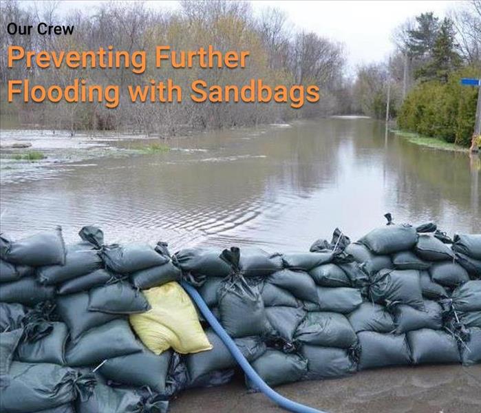 sand bags holding back flood waters in a parking lot